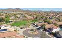 Expansive aerial view showcases the neighborhood with green spaces and mountain views at 2411 W Oberlin Way, Phoenix, AZ 85085