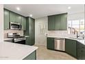 Modern kitchen with green cabinets, stainless steel appliances, quartz countertops and white subway tile backsplash at 2938 N 15Th Ave, Phoenix, AZ 85015