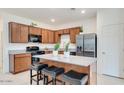 Charming kitchen featuring stainless steel appliances, granite counters, wood cabinets, and a central island with seating at 3010 N Majestic Ct, Casa Grande, AZ 85122