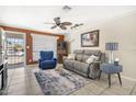 Cozy living room featuring tile floors, an area rug, ceiling fan, and a comfortable seating arrangement at 3243 E Forge Ave, Mesa, AZ 85204