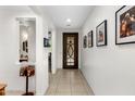 Bright hallway featuring tile floors, white walls, and decorative wall art at 4710 E Tierra Buena Ln, Phoenix, AZ 85032