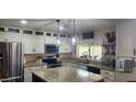 Well-lit kitchen with stainless steel appliances, granite countertops, and a stylish kitchen island at 4855 W Turquoise Ave, Glendale, AZ 85302