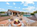 Inviting backyard oasis with a pool, a fire pit with lounge chairs, and an outdoor kitchen perfect for entertaining at 5830 W Cinnabar Ave, Glendale, AZ 85302