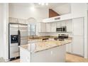 Well-lit kitchen featuring stainless steel appliances, granite countertops, and a central island at 5830 W Cinnabar Ave, Glendale, AZ 85302