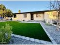 Charming single-story home boasts a lush lawn, desert landscaping and updated curb appeal at 817 N 95Th Pl, Mesa, AZ 85207