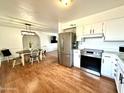 Well-lit kitchen flowing into living space, showcasing stainless steel appliances and white cabinets at 817 N 95Th Pl, Mesa, AZ 85207