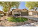 Lovely home featuring mature trees, a well-kept lawn, and a spacious two-car garage at 9331 W Harmony Ln, Peoria, AZ 85382