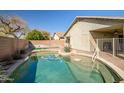 Inviting backyard pool area with mature landscaping and privacy wall at 9331 W Harmony Ln, Peoria, AZ 85382