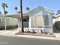 Well-kept single-story home with front yard landscaping including rocks and palm trees at 1027 S Prospector Dr, Apache Junction, AZ 85119