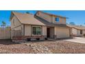 A tan two-story home featuring a two-car garage and a low-maintenance rock front yard at 1027 W Natal Ave, Mesa, AZ 85210