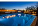 Relaxing pool with fire feature, a built-in bar, and scenic views for outdoor enjoyment at 10381 E Loving Tree Ln, Scottsdale, AZ 85262
