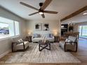 Well-lit living room with hardwood floors, ceiling fan, and a comfortable seating arrangement at 1142 E El Camino Dr, Phoenix, AZ 85020