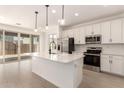Open kitchen with stainless appliances, a center island, and sliding glass doors leading to the backyard at 11619 W Green Dr, Youngtown, AZ 85363