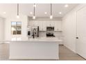 Bright, modern kitchen with stainless steel appliances, white cabinets, and a spacious center island at 11619 W Green Dr, Youngtown, AZ 85363