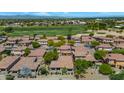 Expansive aerial view captures a community with well-maintained homes, green spaces, and a golf course in the background at 13587 W Cypress St, Goodyear, AZ 85395