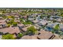 Wide aerial shot displaying a neighborhood with tile roofs, verdant landscaping, and community amenities in the distance at 13587 W Cypress St, Goodyear, AZ 85395