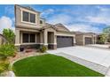 Inviting home with a lush green lawn, showcasing an attached two-car garage at 17263 N Bala Dr, Maricopa, AZ 85138