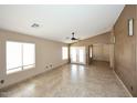 Bright living room with neutral paint, tile flooring, and a view to the backyard at 21047 N Alma Dr, Maricopa, AZ 85138