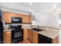 The kitchen features wood cabinets, granite countertops, black appliances, and a double sink at 34924 N 30Th Ave, Phoenix, AZ 85086