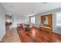 Bright dining room with hardwood floors, a wooden table with upholstered chairs, and a large window at 35282 N Shorthorn Trl, San Tan Valley, AZ 85143