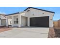 A single story home featuring a black garage door and drought resistant landscaping at 3889 S 233Rd Ln, Buckeye, AZ 85326