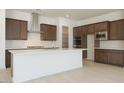 Bright kitchen featuring dark cabinetry, a white quartz island, and stainless steel appliances at 40129 N Alameda Dr, San Tan Valley, AZ 85140