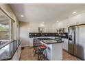 Bright kitchen featuring white cabinets, black countertops, stainless steel appliances, and a kitchen island with seating at 7430 E Coronado Rd, Scottsdale, AZ 85257