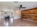 Open floor plan with a view into kitchen and dining area with feature wooden wall and ceiling fan at 7430 E Coronado Rd, Scottsdale, AZ 85257