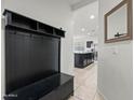 Inviting foyer with coat rack and bench that offers views of the kitchen with dark cabinets and stainless appliances at 7749 W Florence Ave, Phoenix, AZ 85043