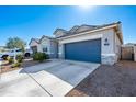A modern single-Gathering home with a spacious driveway, two-car garage, and drought-tolerant landscaping at 7749 W Florence Ave, Phoenix, AZ 85043