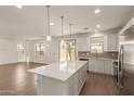 Open-concept kitchen boasts a spacious island, stainless steel appliances, and seamless flow into the adjacent living area at 11623 W Green Dr, Youngtown, AZ 85363