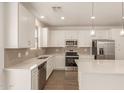Modern kitchen featuring white cabinets, stainless steel appliances, a subway tile backsplash, and a stylish island at 11623 W Green Dr, Youngtown, AZ 85363