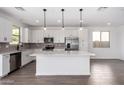 Bright kitchen with a center island, stainless steel appliances, and stylish pendant lighting at 11627 W Green Dr, Youngtown, AZ 85363