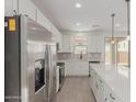 Modern kitchen with stainless steel appliances, an island, and sleek white cabinets at 11631 W Green Dr, Youngtown, AZ 85363
