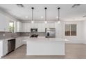 Bright kitchen features white cabinets, stainless steel appliances, and an island for added workspace at 11635 W Beck Ave, Youngtown, AZ 85363