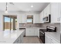 Kitchen boasting stainless steel appliances, white cabinets, and tile backsplash, providing a sleek and modern feel at 11635 W Beck Ave, Youngtown, AZ 85363