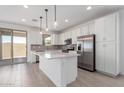 Bright kitchen with stainless steel appliances, white cabinets, tile backsplash, and a center island at 11635 W Beck Ave, Youngtown, AZ 85363