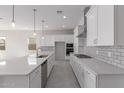 Open concept kitchen boasts stainless appliances, white cabinetry, and quartz countertops at 12022 W Marguerite Ave, Avondale, AZ 85323