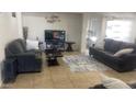 Comfortable living room with tile flooring, neutral tones, and ample seating at 13001 W Aster Dr, El Mirage, AZ 85335