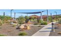 Community amenity area featuring playground equipment and a shaded bench with lush green trees at 13448 W Auburn Dr, Peoria, AZ 85383