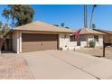 Street view of a well-maintained single-story home with neutral colors and desert landscaping at 1434 W Meseto Ave, Mesa, AZ 85202