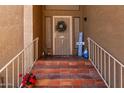 Inviting front entrance with brick steps, decorative plants, and wrought iron details at 17466 N 64Th Ave, Glendale, AZ 85308