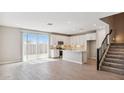 Bright, open-concept living area with modern kitchen, stylish staircase, and wood-look tile floors at 21248 N 58Th St, Phoenix, AZ 85054