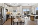Bright eat-in kitchen featuring white cabinets, island seating, and stainless appliances at 2843 W Eagle Talon Rd, Phoenix, AZ 85085