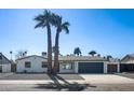 Charming single-story home featuring a two-car garage, desert landscaping, and tall palm trees at 3417 E Lupine Ave, Phoenix, AZ 85028