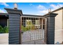 Unique metal gate with black brick pillars, offering privacy and security to the home's entrance and courtyard at 7042 N 12Th Way, Phoenix, AZ 85020