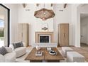 Stylish living room showcasing a fireplace, wooden beams, and a unique woven pendant light at 7157 E Bronco Dr, Paradise Valley, AZ 85253