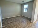 This bedroom boasts stylish wood-look tile flooring and a bright window at 7272 E Hackamore Ln, San Tan Valley, AZ 85143