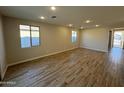 Spacious living room featuring wood-look tile flooring and ample natural light from multiple windows at 7272 E Hackamore Ln, San Tan Valley, AZ 85143