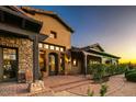 Lovely home exterior displaying unique architecture, an arched door, stone and stucco, and inviting front entrance at 7413 E Lower Wash Pass, Scottsdale, AZ 85266